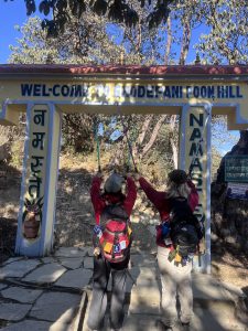 Voyageuses posant devant le panneau Welcome to Ghodepani Poon Hi